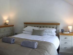 a bedroom with a bed with two pillows on it at Pantglas in Llandysul +9 photos