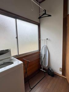 a kitchen with a window and a washing machine at 民泊びんご1 in Onomichi