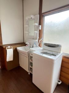 a small bathroom with a sink and a mirror at 民泊びんご1 in Onomichi