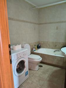 a bathroom with a toilet and a washing machine at Agios Stefanos TwoStory Maisonette in Néa Zoryiáni +10 photos