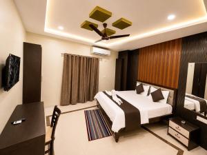 a hotel room with a bed and a desk and a room at Hotel Balaji Inn in Raipur +3 photos