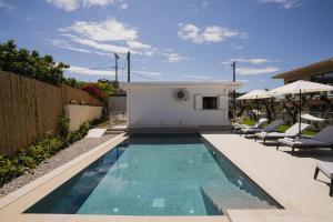 a swimming pool in a backyard with chairs and a house at Moonlit Villa in Planos