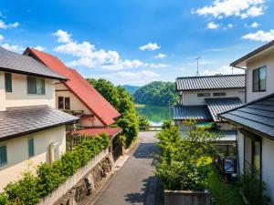 a street between houses with a lake in the background at HS Japan STAY 瀬戸内 in Takamatsu