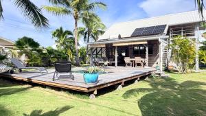 a house with a deck with a table and chairs at Moorea Fare Korail in Temae