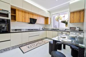 a kitchen with white cabinets and a glass table at Villa 33 Ultra Lux High-End in Tangier