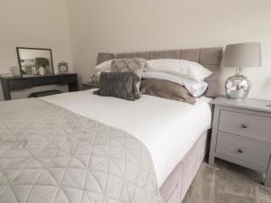 a bedroom with a large white bed with a nightstand at Apartment 20, River View in Preston