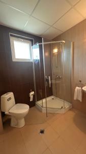 a bathroom with a shower and a toilet and a sink at Корал in Obzor +77 photos