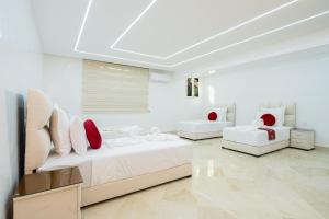 a white room with two beds and red pillows at Villa 33 Ultra Lux High-End in Tangier +86 photos