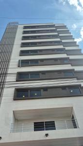 a tall white building with many windows at Il Divo Boutique Hotel in Ciudad del Este