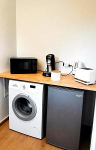 a kitchen counter with a washing machine and a microwave at Natura2000 in Châteauroux +21 photos