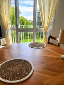 two mats on a wooden table with a large window at Natura2000 in Châteauroux