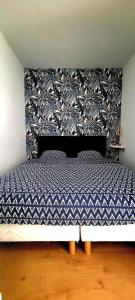 a bedroom with a bed with a blue and white pattern at Natura2000 in Châteauroux