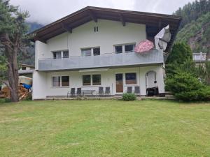 a large white house with a large yard at Appartement Milli in Längenfeld