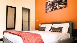 a bedroom with orange walls and a bed with two pillows at Palazzo Goyze in Naples