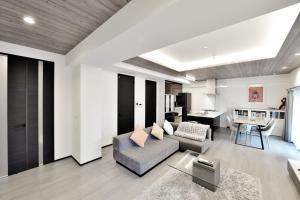 a living room with a couch and a table at Room 701 Large 3LDK 98sqm Near Namba Big Balcony Ideal for Groups and Long Stay in Osaka