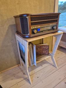 a table with an old radio on top of it at Lake window in Škofja Vas