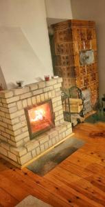 a brick fireplace in a living room with wood floors at Dom Widny Jaś zaprasza nad jezioro na Kaszuby in Sulęczyno