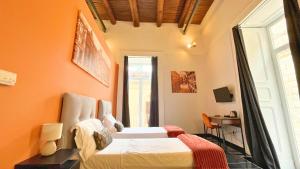 a bedroom with two beds and a desk and a window at Palazzo Goyze in Naples