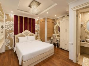 a bedroom with a white bed and a bathroom at Hanoi Silk Classy Hotel & Travel in Hanoi +58 photos