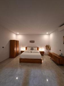 a large bedroom with a bed and two tables at Rumah Asri Devarastra #1 in Amed