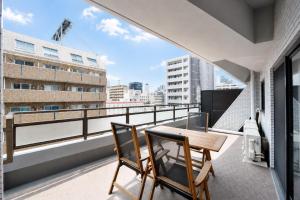 a balcony with a wooden table and two chairs at Room 701 Large 3LDK 98sqm Near Namba Big Balcony Ideal for Groups and Long Stay in Osaka