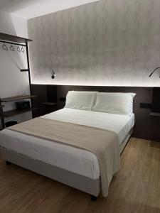 a bedroom with a large bed with white sheets at Le Cantine Rooms & Luxury Space in San Mango Piemonte +71 photos