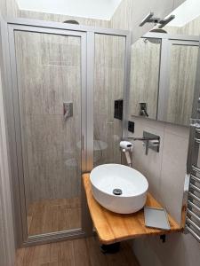 a bathroom with a white sink and a shower at Le Cantine Rooms & Luxury Space in San Mango Piemonte