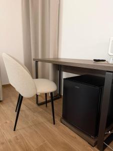 a desk with a white chair and a television at Le Cantine Rooms & Luxury Space in San Mango Piemonte