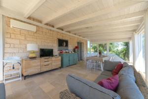 a living room with a couch and a tv at Trullo Theodoro Puglia in Ceglie Messapica