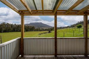 a screened porch with a view of a field and mountains at Rivendell Cottage - Off Grid cabin in Jackeys Marsh