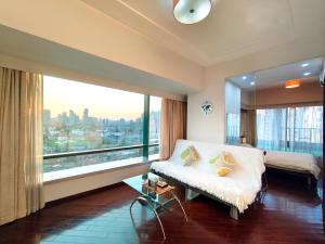 a bedroom with a bed and a large window at Shanghai Cosmo World Union Service Apartment in Shanghai