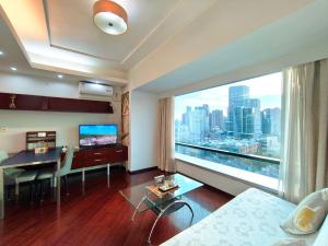 a living room with a table and a large window at Shanghai Cosmo World Union Service Apartment in Shanghai
