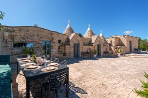 a patio with a table and chairs in front of a building at Trullo Theodoro Puglia in Ceglie Messapica