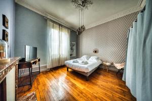 a bedroom with a bed and a desk and a television at La Source de la Scance in Verdun-sur-Meuse