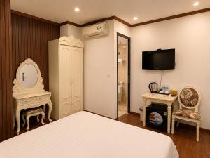 a bedroom with a bed and a mirror and a tv at Hanoi Silk Classy Hotel & Travel in Hanoi
