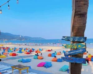 a beach with a bunch of umbrellas and people at Board & Beyond House in Danang