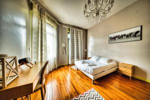 a bedroom with a bed and a chandelier at La Canopée in Verdun-sur-Meuse