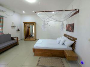 a bedroom with a bed and a couch in it at Villa Tsara Nosy be in Nosy Be +41 photos