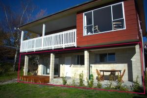 a house with a deck and a table in the yard at Dark Sky Retreat in Lake Tekapo