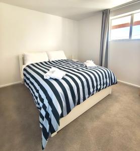 a bedroom with a black and white striped bed at Dark Sky Retreat in Lake Tekapo
