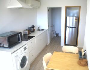 a kitchen with a refrigerator and a table with a microwave at Dark Sky Retreat in Lake Tekapo