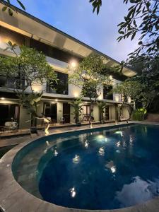 an image of a swimming pool in front of a house at White Rock Lodge in Nusa Dua