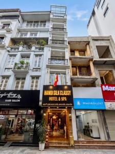 a tall white building with a sign for a hotel at Hanoi Silk Classy Hotel & Travel in Hanoi