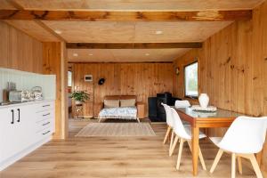 a kitchen and dining room with a table and chairs at Rivendell Cottage - Off Grid cabin in Jackeys Marsh