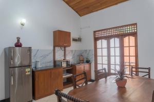 a kitchen with a wooden table and a refrigerator at Ditara in Katugastota