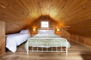 a bedroom with two beds in a wooden attic at Rivendell Cottage - Off Grid cabin in Jackeys Marsh