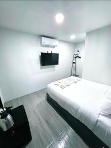 a bedroom with a white bed and a flat screen tv at Cloud Bed Ao Nang- High Speed internet, Comfort bed , Smart Tv in Ao Nang Beach +10 photos