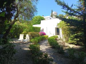 a white house with some bushes and trees at Bonanova 20 in Palma de Mallorca