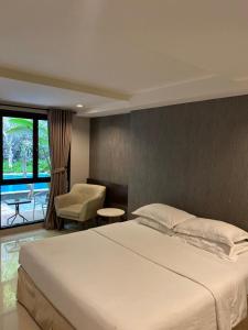 a bedroom with a large white bed and a chair at White Rock Lodge in Nusa Dua +24 photos