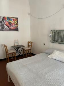a bedroom with a bed and a table and chairs at Cà Bartolomeo in Finale Ligure +15 photos
